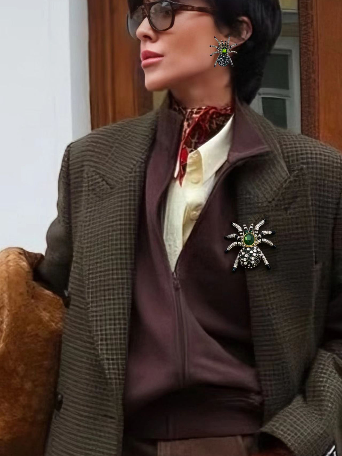 Green spider brooch styled on brown blazer